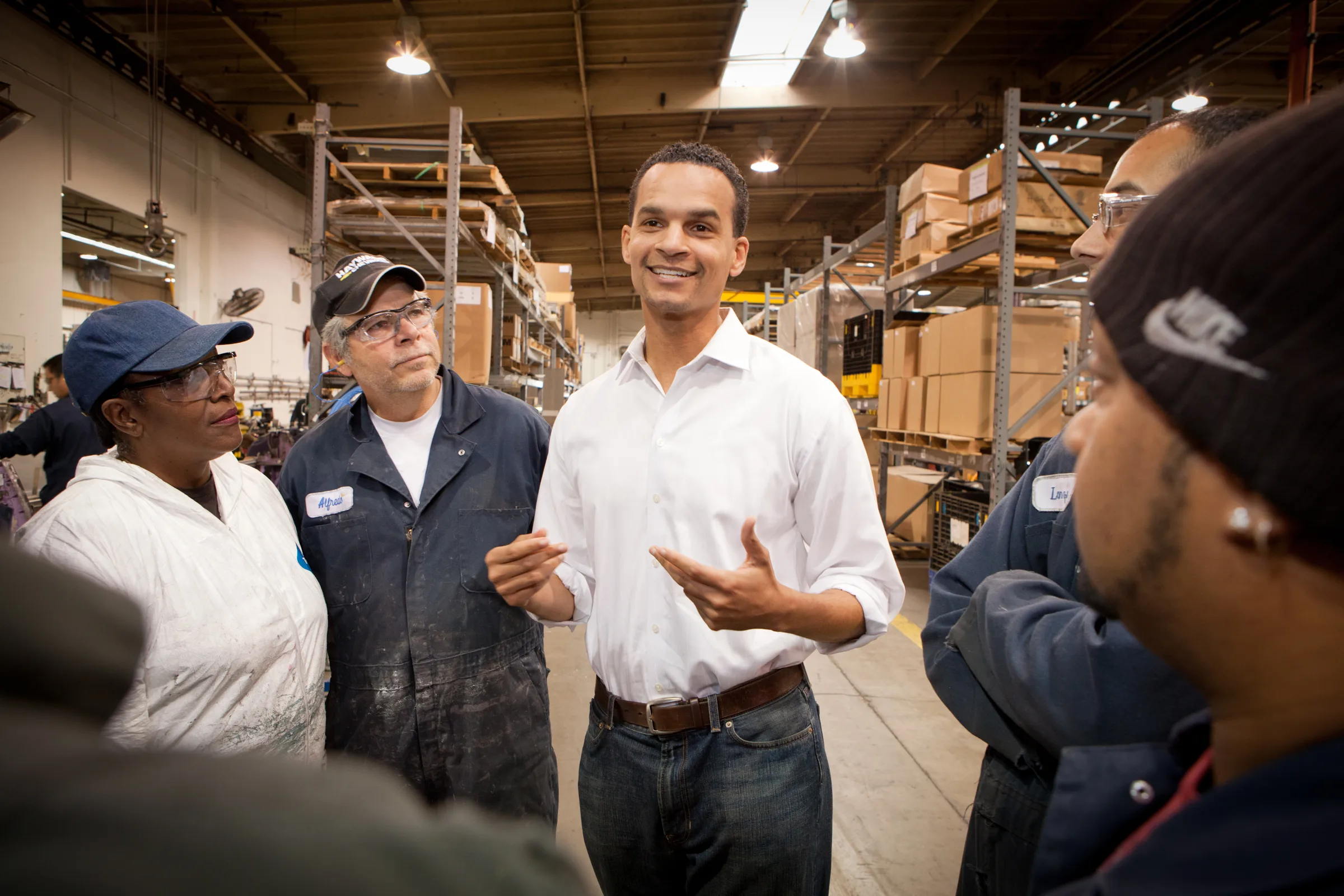 Joel Young talking with workers on a warehouse floor