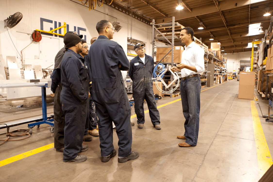 Joel Young speaking with workers at a local manufacturing facility